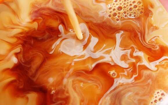 close up of milk on black tea