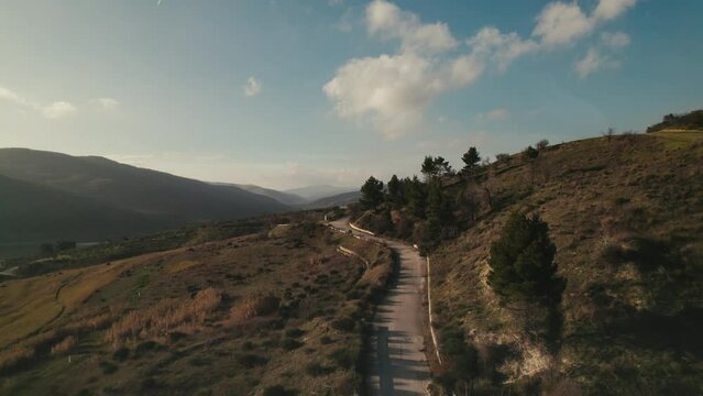 Colorful and dreamy countryside road by a lake in the mountains at sunrise in Basilicata, Lake of Acerenza, Italy 4K drone
