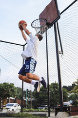 Basketball player jumping high to make a slam dunk to the basket