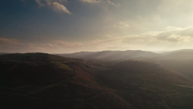 Colorful and dreamy aerial of a bridge in the mountains at sunrise in Basilicata, Lake of Acerenza, Italy 4K drone