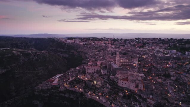 Magic hour sunset aerial over the Ancient Jerusalem looking city of Matera in Basilicata, Italy and its ravine