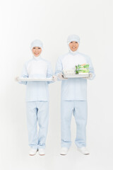 食品を持つ防護服姿の男女