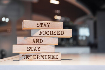 Wooden blocks with words 'Stay focused and stay determined'.