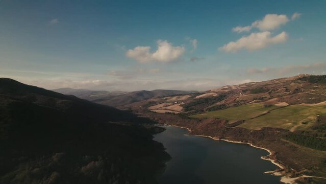 Colorful and dreamy aerial of a lake in the mountains at sunrise in Basilicata, Lake of Acerenza, Italy 4K drone