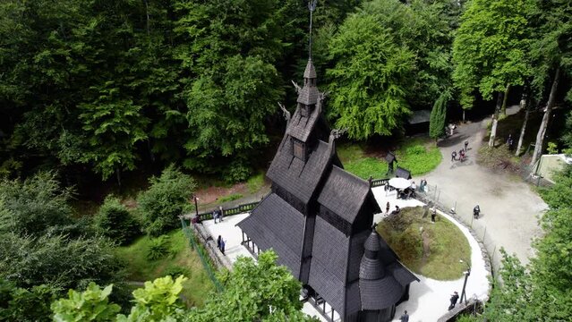 People visiting the Fantoft Stave church, in sunny Norway - circling, drone shot