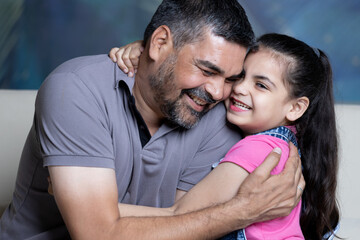 Portrait of father and daughter at home having fun together