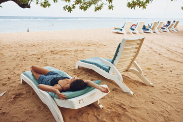 woman sunbed lifestyle sand resort recreation sea beach lying ocean smiling