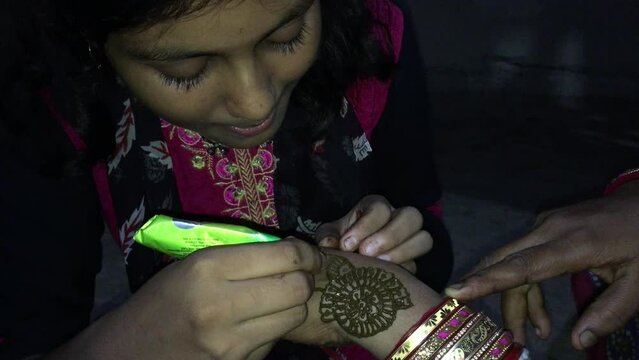 Mehndi painting on a hand of a beautiful young indian woman