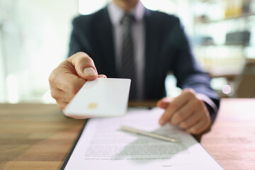 Man in suit holds credit card ready to pay for services