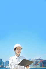 現場を確認する作業着姿の女性