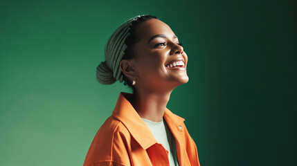Fototapeta premium Smiling young adult woman looking happily in studio portrait with green background and plenty of copy space. generative ai