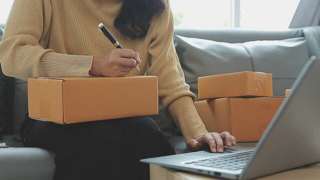 Business woman start up small business entrepreneur SME success .freelance woman working at home with Online Parcel delivery. SME and packaging deliveryconcept