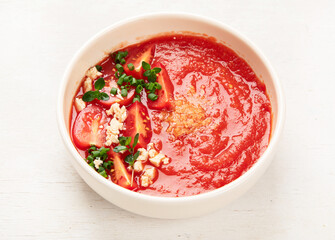 Tomato soup on white table, top view