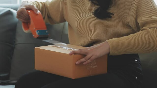 Business woman start up small business entrepreneur SME success .freelance woman working at home with Online Parcel delivery. SME and packaging deliveryconcept