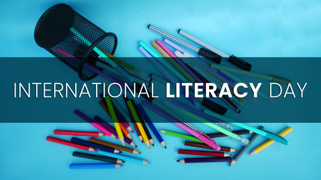 Colored pencil spilled from the case with torn paper incription of world literacy day.