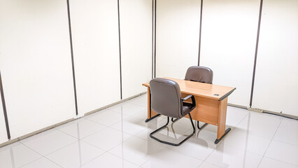 Wooden table furniture and two modern armchairs in the interrogation room