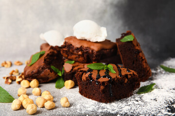 Pieces of tasty chocolate brownie with ice cream on grunge background