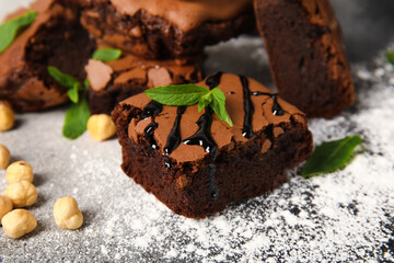 Pieces of tasty chocolate brownie on light background, closeup