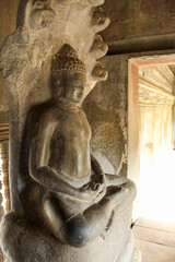 Murals and sculptures of Buddha, Vishnu, Shiva, Hindu god symbol, face in ancient temple ruins of...