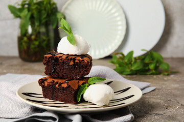 Plate with pieces of tasty chocolate brownie and ice cream on table