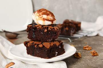 Plate with pieces of tasty chocolate brownie and ice cream on table