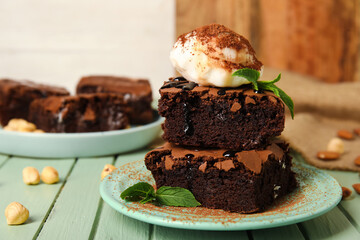 Plate with pieces of tasty chocolate brownie and ice cream on table