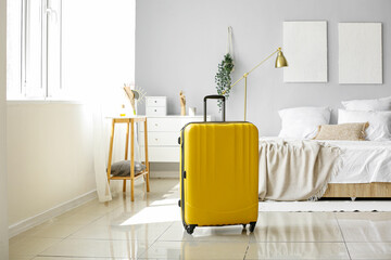 Fototapeta Yellow suitcase in light bedroom obraz