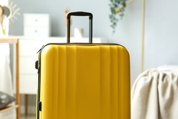 Yellow suitcase in light bedroom