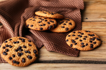 Tasty cookies with chocolate chips on wooden background