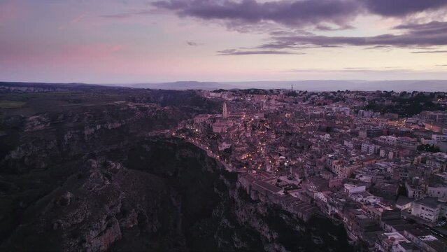 Magic hour sunset aerial over the Ancient Jerusalem looking city of Matera in Basilicata, Italy and its ravine
