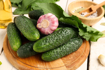 Wooden board with fresh cucumbers for preservation on table