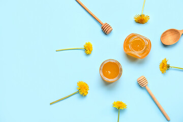 Jars with dandelion honey on turquoise background