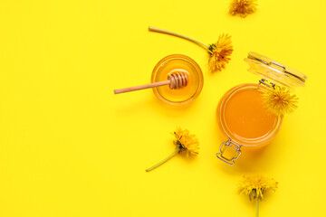 Jar and bowl with dandelion honey on yellow background