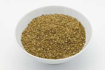 A bowl of dried oregano isolated on white background.