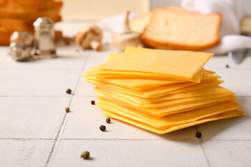 Slices of tasty processed cheese on table
