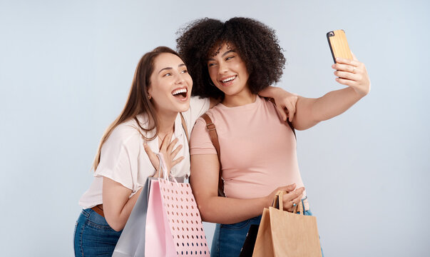 Friends, women with shopping bag and happy in selfie, retail customer and fashion isolated on studio background. Excited female people smile in picture, sale and discount with promotion at boutique