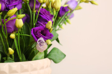 Vase with eustoma flowers on white background