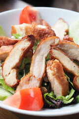 Grilled chicken and fresh vegetable salad on table.