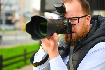 The paparazzi is seen taking a photo of a celebrity in an urban setting. The photographer is...
