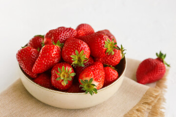 Bowl with fresh strawberries on white background