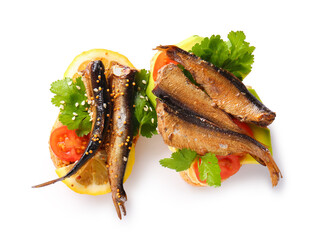 Tasty sandwiches with canned smoked sprats on white background