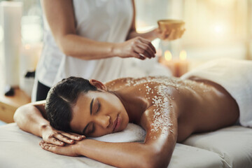 Woman, sleeping and relax in salt scrub massage at spa for skincare, exfoliation or body treatment....