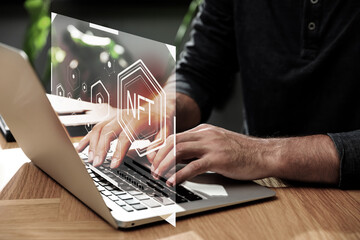 Man using laptop at table, closeup. Interface with abbreviation NFT (non-fungible token) near device
