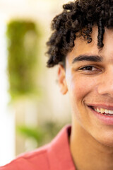 Half portrait of happy biracial man with curly black hair smiling at home, with copy space