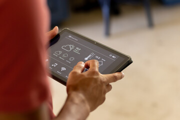 Hands of biracial man using tablet with smart home interface on screen