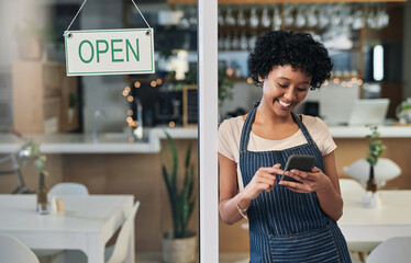 Happy woman, waitress and phone with open sign in communication, social media or online post at cafe. Female person, barista or manager with smile for opening store on smartphone at coffee shop