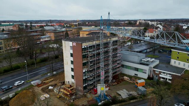 Aerial drone zoom in shot over an empty under construction building site in Brunswick, Germany on a cloudy day.
