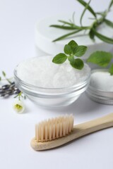 Fototapeta na wymiar Toothbrush, sea salt, dry flowers and green herbs on white background, closeup