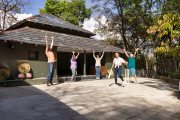Family members playing cricket in the back yard.