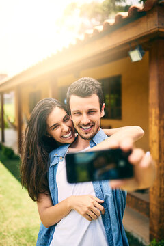 Happy couple, hug and smile for selfie, profile picture or photo together in social media vlog outdoors. Man and woman hugging and smiling for memory, online post or capture outside their home
